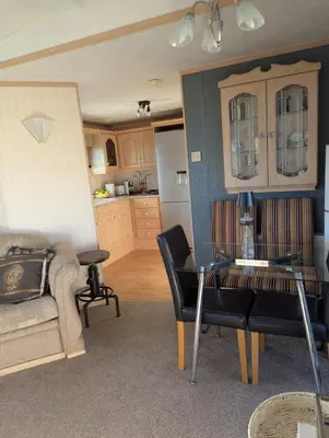 a living room with a table and a kitchen at Aberystwyth holiday village walking distance to beach, town great outside space parking next to property in Aberystwyth