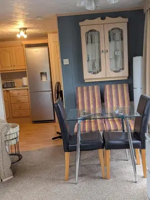 a dining room with a glass table and chairs at Aberystwyth holiday village walking distance to beach, town great outside space parking next to property in Aberystwyth