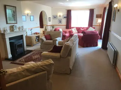 a living room with couches and a fireplace at Heulwen Guest House in Dolgellau