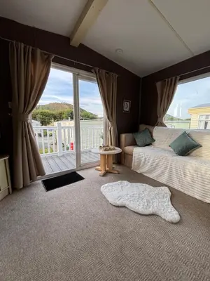 a bedroom with two beds and a large window at Welsh Bayview Retreat 2-Bed Caravan & 2-Bed Chalet at Clarach Bay Holiday Village in Aberystwyth