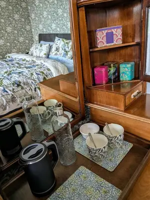 a room with a bed and a table with dishes at Aelybryn in Llangwyryfon