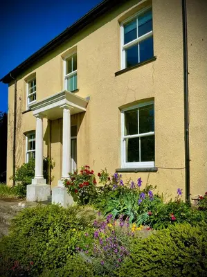 a house with a bunch of flowers in front of it at Aelybryn in Llangwyryfon
