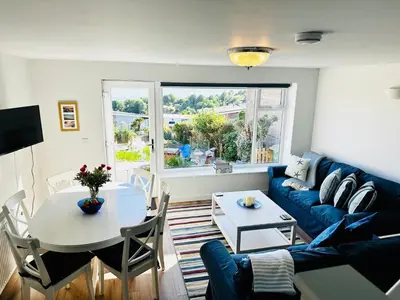 a living room with a blue couch and a table at Ynyslas View in Aberdyfi