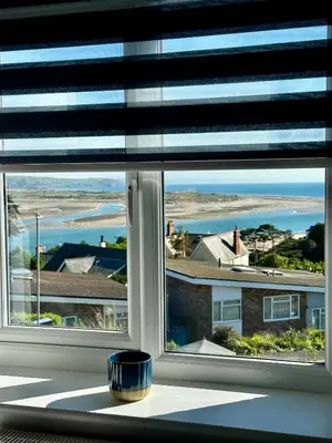 a window with a view of the ocean through it at Ynyslas View in Aberdyfi