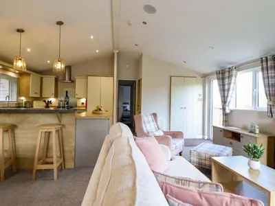 a living room with a couch and a kitchen at The Owlet in Llanidloes