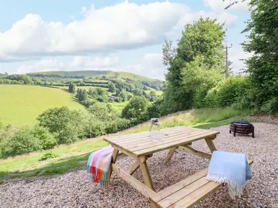 a wooden picnic table sitting on top of a hill at The Owlet in Llanidloes