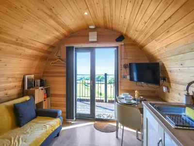 a room with a couch and a table and a tv at Sunset Holiday Pod - Uk48592 in Church Stretton