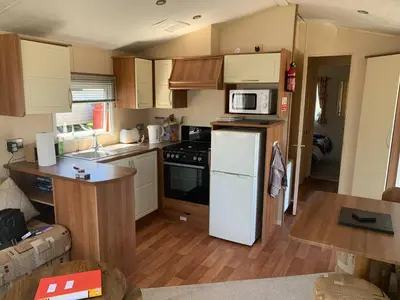 a kitchen with a white refrigerator and a microwave at 63 Bardsey View Holiday Park in Mydroilin