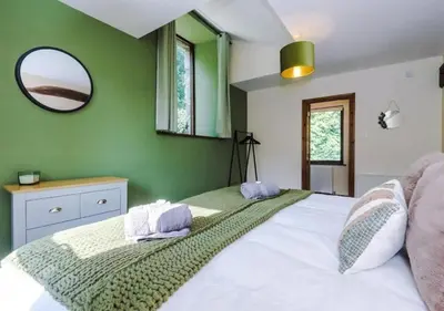 a bedroom with a large white bed with a mirror at Peaceful Barn Near Cader Idris in Dolgellau