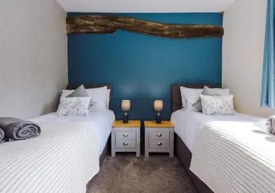 two twin beds in a room with blue walls at Peaceful Barn Near Cader Idris in Dolgellau