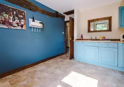 a kitchen with a blue wall and a sink at Peaceful Barn Near Cader Idris in Dolgellau