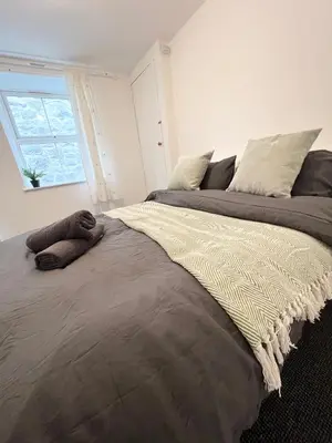 a large bed in a bedroom with a window at Cosy Cader Cottage in Dolgellau