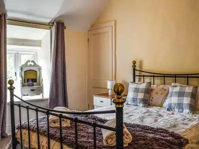 a bedroom with a bed and a mirror at Priory Cottage in Clifford