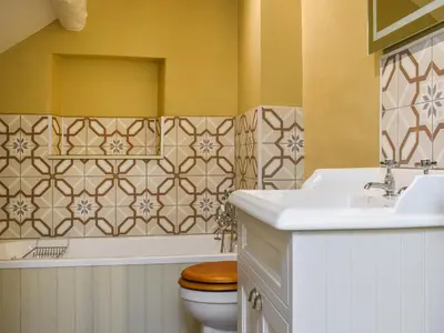 a bathroom with a sink and a toilet and a tub at Priory Cottage in Clifford