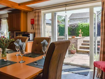a dining room with a wooden table with chairs at Priory Cottage in Clifford