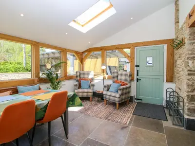 a conservatory with a table and chairs and a door at 10 Bridge Street in Craven Arms