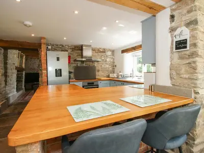 a kitchen and dining room with a wooden table and chairs at 10 Bridge Street in Craven Arms