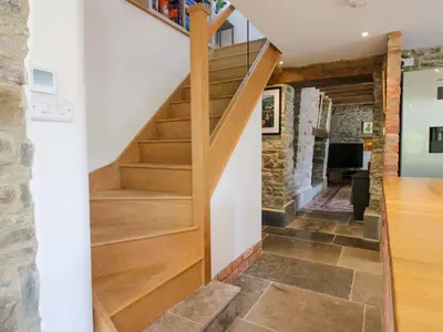 a wooden staircase in a house with a stone wall at 10 Bridge Street in Craven Arms