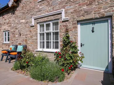a brick building with a blue garage door and a window at 10 Bridge Street in Craven Arms