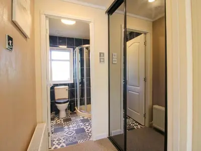 a bathroom with a toilet and a glass door at Dunromin in Montgomery