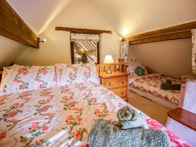 a bedroom with a bed with a dog sitting on a chair at The Long House in Oswestry