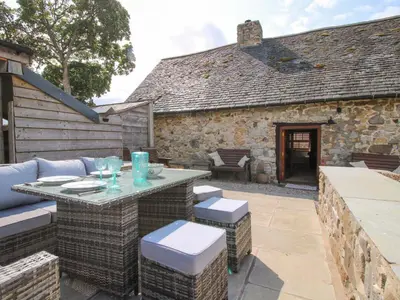 an outdoor patio with a table and chairs at The Long House in Oswestry