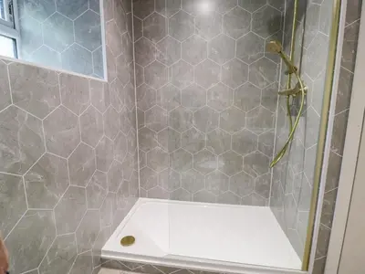 a bathroom with a shower with a glass door at Frongoch Old Power House in Dolgellau