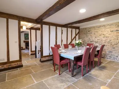 a dining room with a table and red chairs at Upper Dolarddyn in Welshpool