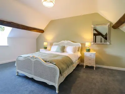 a bedroom with a white bed and a mirror at Upper Dolarddyn in Welshpool