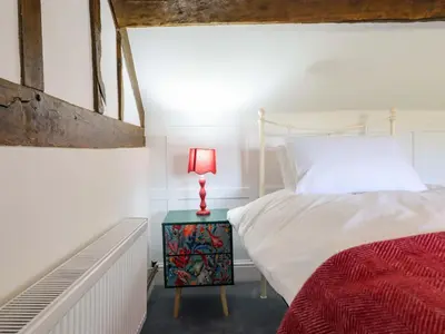 a bedroom with a bed and a lamp on a night stand at Upper Dolarddyn in Welshpool