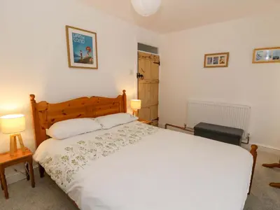 a bedroom with a white bed and two lamps at Hafan Fach in Aberystwyth