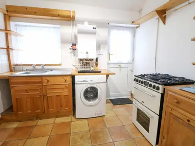 a kitchen with a washing machine and a stove at Hafan Fach in Aberystwyth