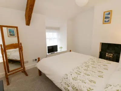 a bedroom with a white bed and a mirror at Hafan Fach in Aberystwyth