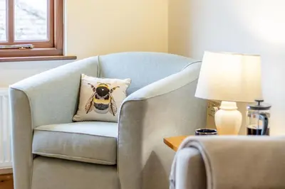 a chair with a pillow on it next to a lamp at 1 Bed in Dorstone oc-c31765 in Dorstone