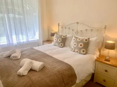 a bedroom with a bed with two towels on it at Riverside Bungalow in Llanbedr