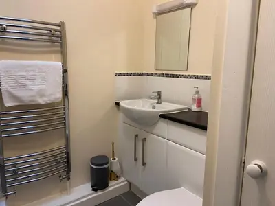 a bathroom with a sink and a toilet and a mirror at Riverside Bungalow in Llanbedr