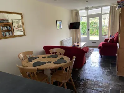 a living room with a table and chairs and a couch at Riverside Bungalow in Llanbedr