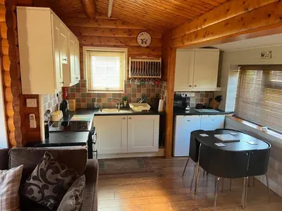 a small kitchen with a table in a room at Home From Home LogCabin in Trawsfynydd