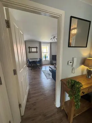 a hallway leading to a living room with a table at Town centre abode with gated parking in Shrewsbury