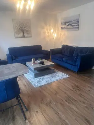 a living room with blue couches and a coffee table at Town centre abode with gated parking in Shrewsbury