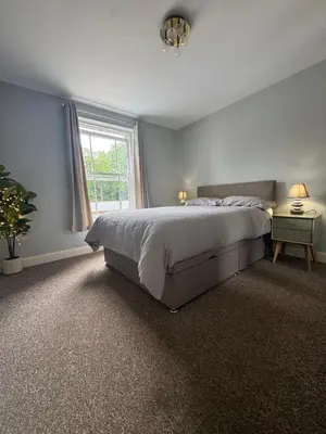 a bedroom with a large bed and a window at Town centre abode with gated parking in Shrewsbury