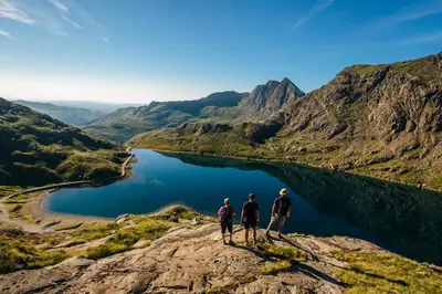 three people standing on top of a mountain overlooking a lake at 2 Bed in Llanarmon Dyffryn Ceiriog oc-b31110 in Llanarmon Dyffryn-Ceiriog
