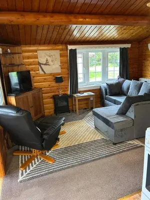 a living room with a couch and a chair at Happy Place LogCabin in Trawsfynydd