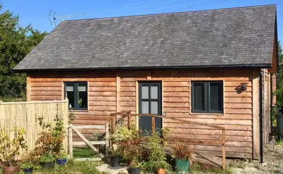 a small wooden cabin with a wooden fence at Little Hare Lodge - Near Ludlow in Lane to Richards Castle