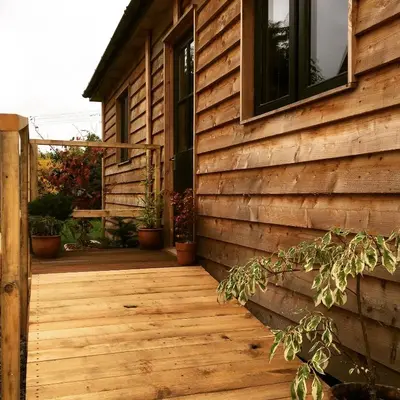 a house with a wooden walkway next to a building at Little Hare Lodge - Near Ludlow in Lane to Richards Castle