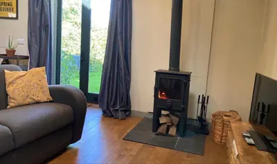 a living room with a wood stove in a room at Little Hare Lodge - Near Ludlow in Lane to Richards Castle