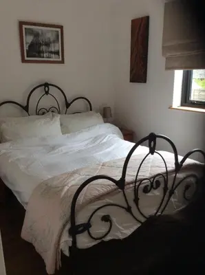 a bedroom with a white bed with a black frame at Little Hare Lodge - Near Ludlow in Lane to Richards Castle