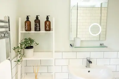 a bathroom with a sink and a mirror at Hen Llwyn by Birch Stays New Home in Llangadwaladr