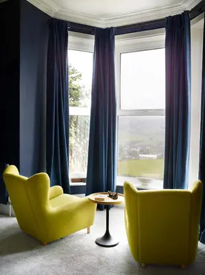 two yellow chairs and a table in front of a window at The Royston in Llanbrynmair
