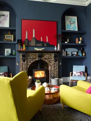 a living room with a fireplace and yellow chairs at The Royston in Llanbrynmair